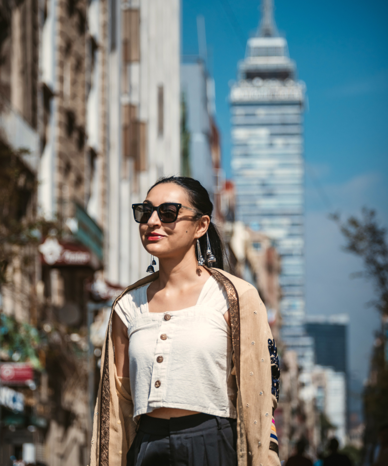 Woman standing wearing Sunglasses with jhumkara